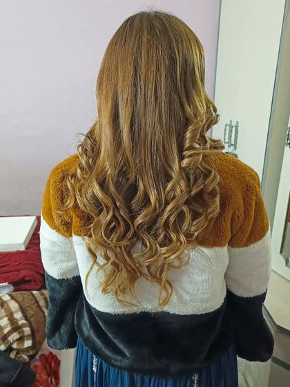 The final result of the open-hair styling, showing soft, natural-looking curls on highlighted hair.