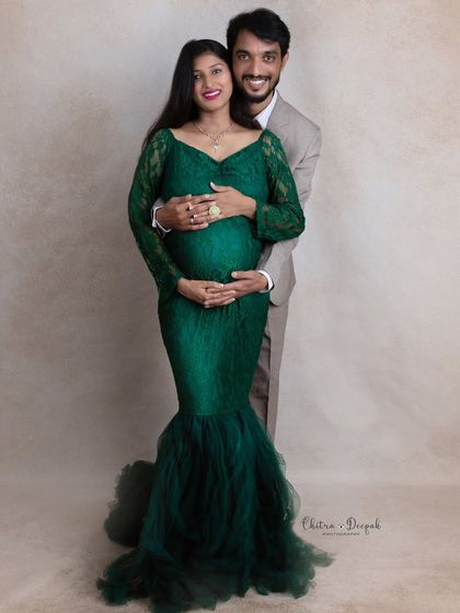 A classic and elegant couple's portrait. The partner's hands gently cradle the baby bump, a timeless pose that symbolizes love and protection.