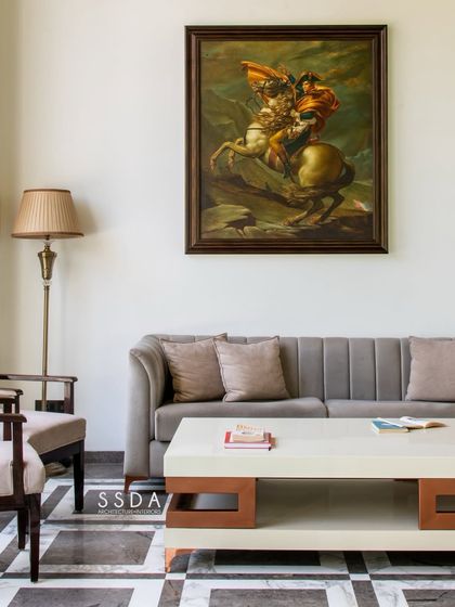 In 'The Green Axis' office, a classic painting and traditional furniture create a formal yet comfortable waiting area. The patterned marble floor adds a touch of historic character to the modern building.