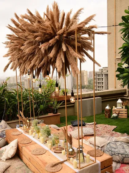 This wide shot shows how the rooftop boho setup creates a stunning silhouette against the city skyline, perfect for a memorable sundowner event.