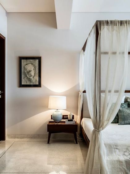 A four-poster bed with light, airy curtains creates a romantic and serene focal point in this bedroom from our Terrazzo Residence project. A custom-designed screen with intricate geometric patterns adds a layer of privacy and decorative detail.