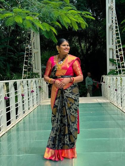 Our client Pavithra looks elegant in this luxurious silk saree with a black floral brocade and a deep pink border.
