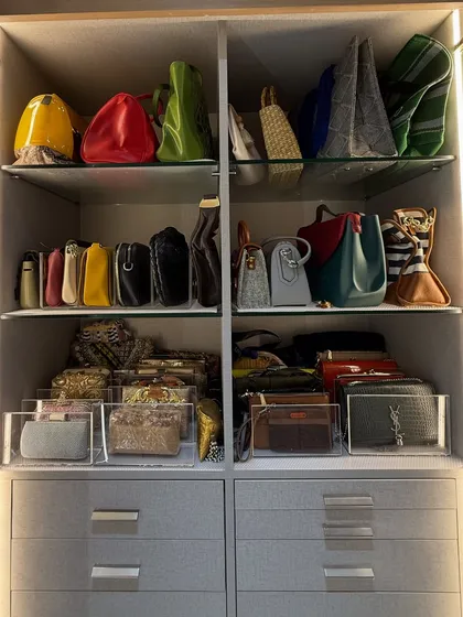 A beautiful display of handbags on glass shelves. We use clear organizers for smaller clutches and wallets, keeping them contained and visible.