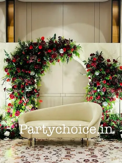 For this sangeet, we created a romantic and dramatic stage with arches of deep red flowers. The dark red roses and foliage stand out against the white backdrop, with hanging chandeliers adding a touch of elegance.