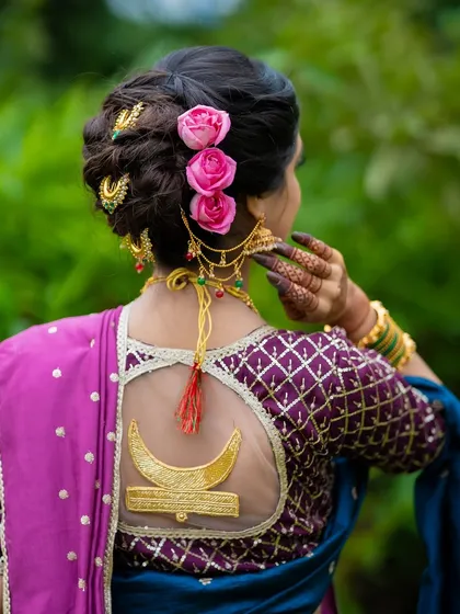 Bridal beauty is also about the details from behind. I specialize in creating intricate traditional hairstyles like this beautiful khopa, adorned with fresh roses and a custom blouse design, completing the symphony of Maharashtrian grace.