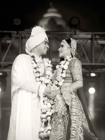 A classic black and white shot of Anmol and Deepali during their varmala ceremony. This timeless style focuses on their expressions and the emotional connection between them.