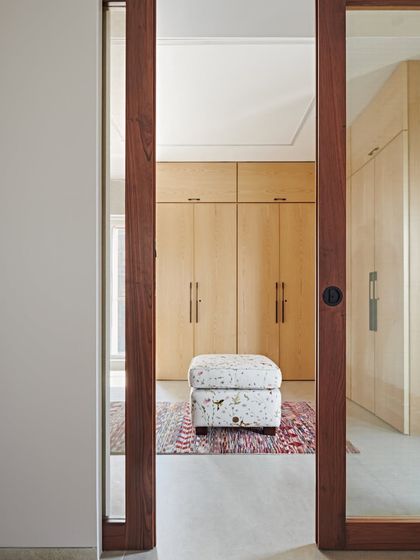 We believe in maximizing functionality through smart planning. This view into a walk-in closet at the Maximum City Duplex shows our approach to creating ample storage that is seamlessly integrated into the bedroom's design.