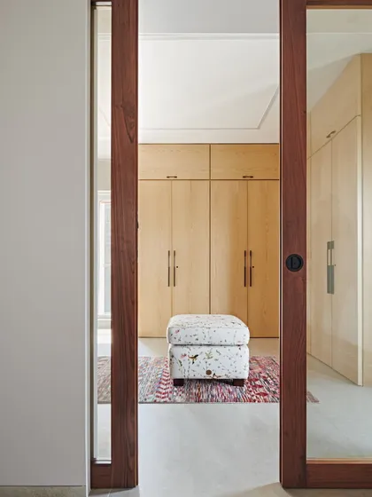 We meticulously plan our bedrooms to maximize efficiency. This view into a walk-in closet at the Maximum City Residence shows our commitment to creating ample storage, ensuring that living spaces remain uncluttered.