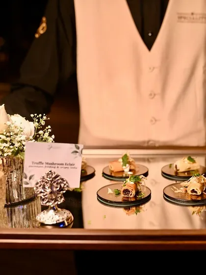 Our staff presenting a tray of Truffle Mushroom Éclairs, a signature appetizer, at an anniversary celebration in Kolkata.