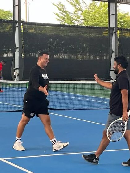 Sportsmanship and camaraderie are at the heart of our Adults Doubles League. Here, two players share a high-five between points.