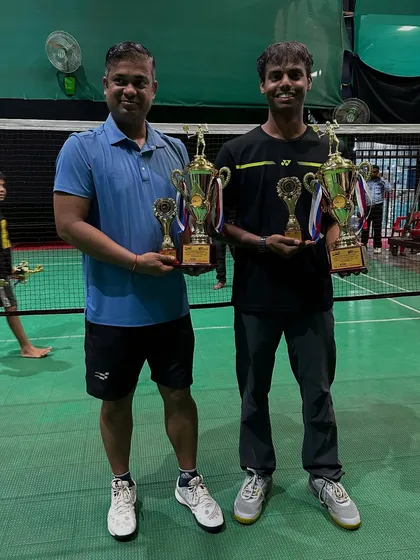 B Group Men's Doubles winners, Vedant and Kiran K, with their impressive collection of trophies.