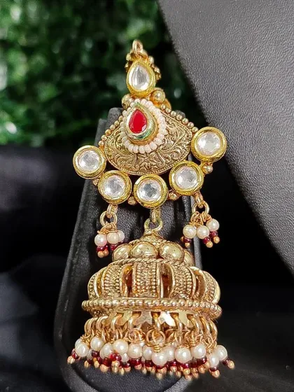 A classic temple-style jhumka with a crown-like top and pearl drops.