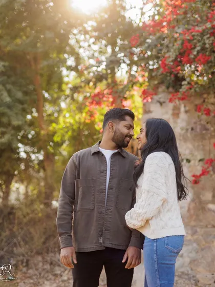 The backlighting from the Delhi winter sun creates a beautiful halo effect in this shot. The vibrant red flowers add a pop of color to this romantic couple portrait.