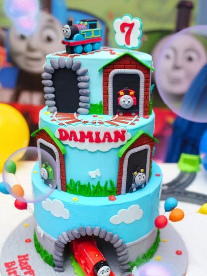 All aboard for Damian's 7th birthday. This three-tier Thomas & Friends cake featured a rotating train centerpiece that brought the theme to life.