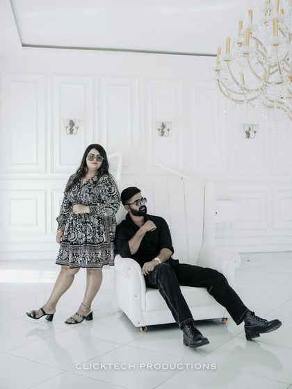 A cool, high-fashion pose in the all-white room, with the couple exuding confidence and style.