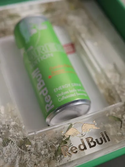 A close-up of the Red Bull Green Edition PR package, showing the custom resin frame with a Red Bull can embedded within it.