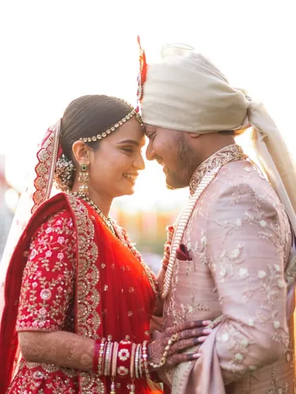 A sweet and tender moment during a Gujarati wedding photoshoot. The setting sun provides a perfect golden glow for this romantic couple portrait.