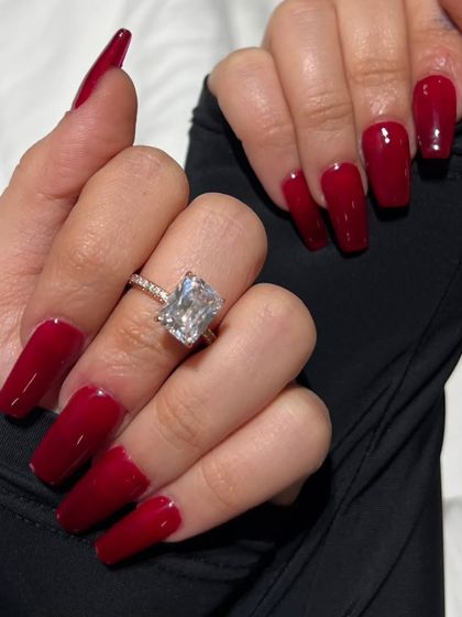 A close-up of the classic red coffin nails, highlighting the rich color and impeccable glossy finish.