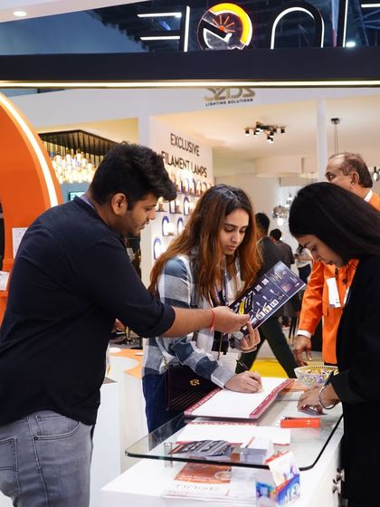 Visitors register at a booth, eager to learn more about the exclusive filament lamps and other products on display.
