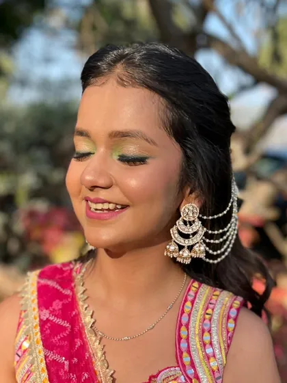 A close-up of the green-accented eye makeup. The shimmer on the lid and the pop of color below create a captivating effect.