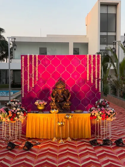 A wider view of the Ganpati decor, showing the complete setup with a yellow table skirt and a traditional patterned carpet.