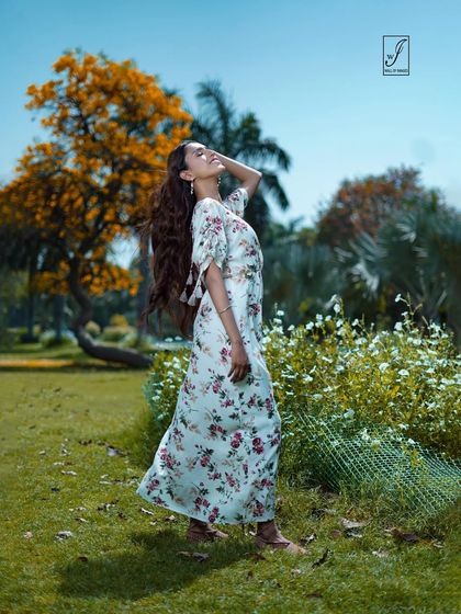 A model soaks in the sun in a beautiful floral dress. This shot is all about capturing a feeling of warmth and freedom in a natural park setting.