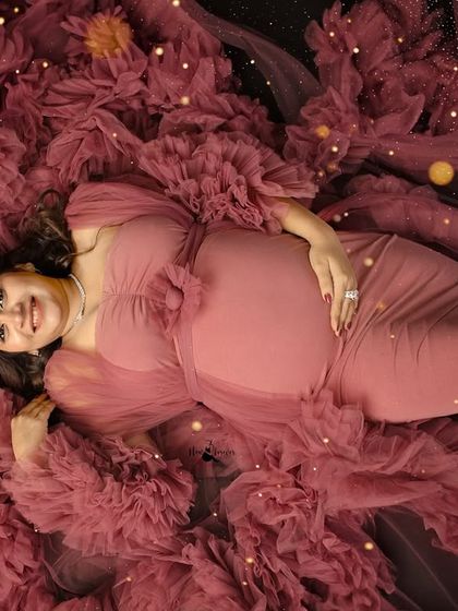 Lying in a bed of ruffled fabric, this mother-to-be looks so peaceful and happy. I use creative angles and lighting to add a touch of magic to these studio portraits.