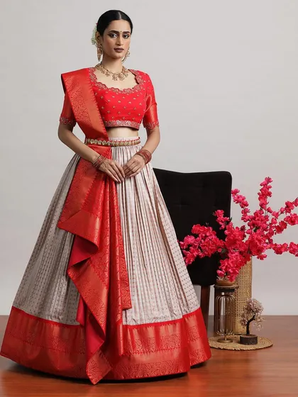 The same red and beige lehenga from a different angle, showing the beautiful drape of the Banarasi silk.