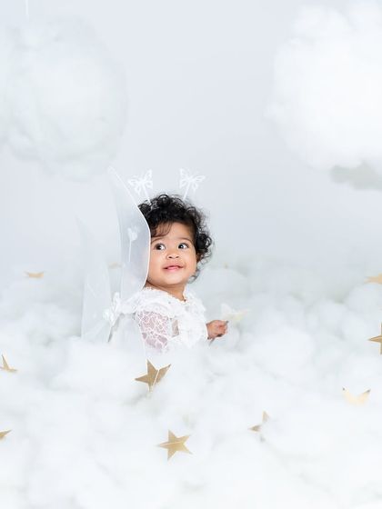 A little angel floating on a cloud. This dreamy setup with soft cotton clouds and golden stars is perfect for capturing the innocence of a sitter session.
