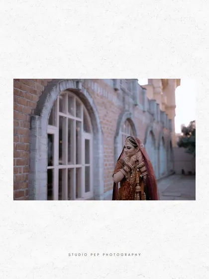 A wide shot of Nisha against a brick wall, the simple background making her ornate lehenga the star of the photo.