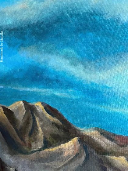 Another angle of my work-in-progress acrylic mountain painting. This view focuses on the dramatic clouds and the peaks of the mountains, showing the texture of the canvas and the layers of paint.