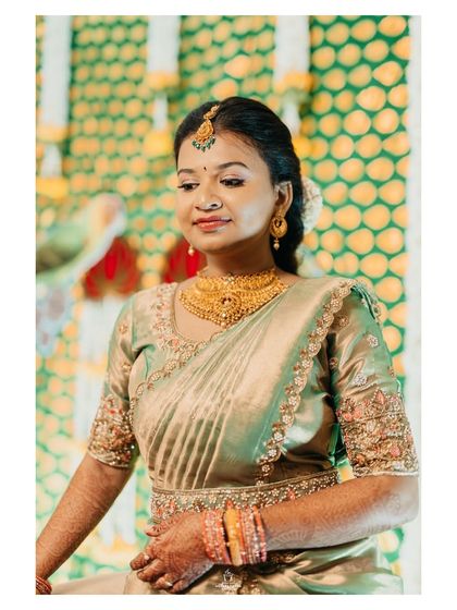A portrait of a bride on her engagement day, looking elegant in a green and pink half-saree.