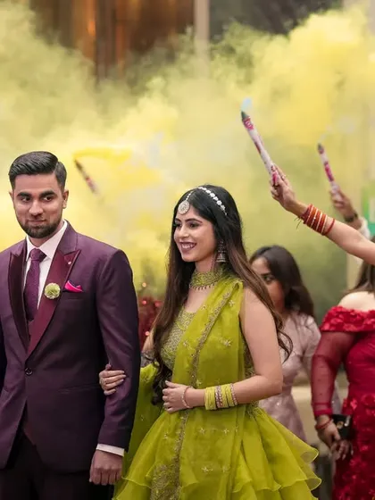 A grand entry with yellow smoke bombs, this photo captures the couple's stylish and fun entrance to their pre-wedding function.