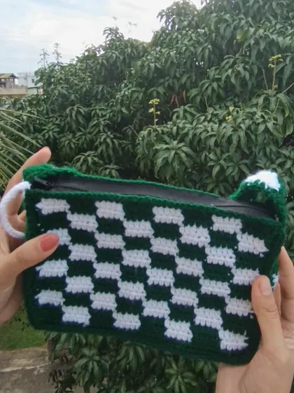 Showing the interior of the checkered bag, which is lined and includes a zipper for security.