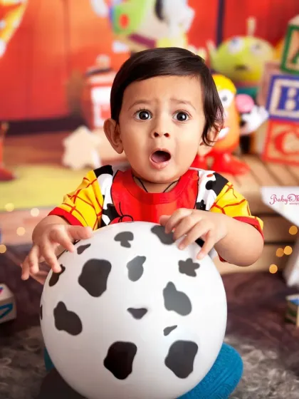 To infinity and beyond! This little Woody from Toy Story is just the cutest. His surprised expression is priceless, making this a truly memorable first birthday photo.