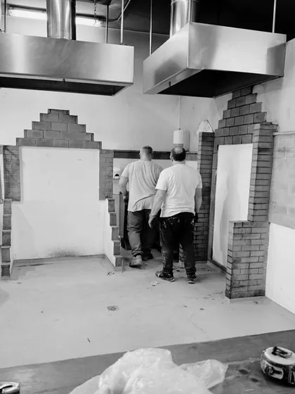 A black and white photo from the interior construction of our restaurant project in Ibiza, Spain. This image captures the early stages of the fit-out, with brick archways being mocked up, hinting at the design elements to come.