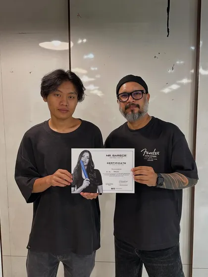 Every student gets the chance to shine and be recognized for their hard work. This student is receiving his certificate after an intensive advanced haircutting workshop.