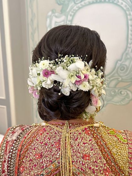 A closer view of the floral arrangement, showing the texture and variety of flowers used to create this stunning bridal hairstyle.
