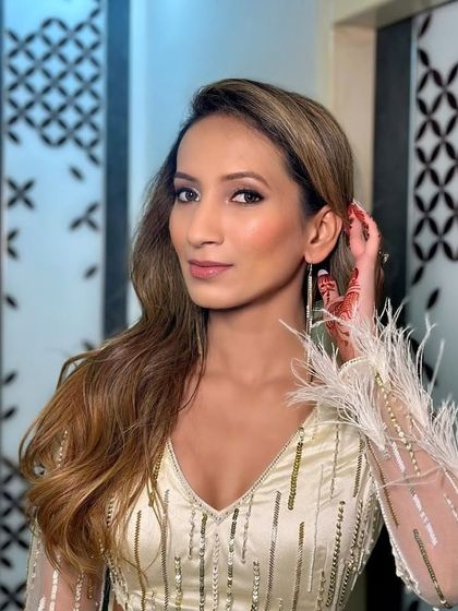 A close-up on the details of this custom party dress. The sheer sleeves are adorned with lines of self-colored cutdana and salis, and the cuffs are finished with soft feathers for a touch of playful luxury.