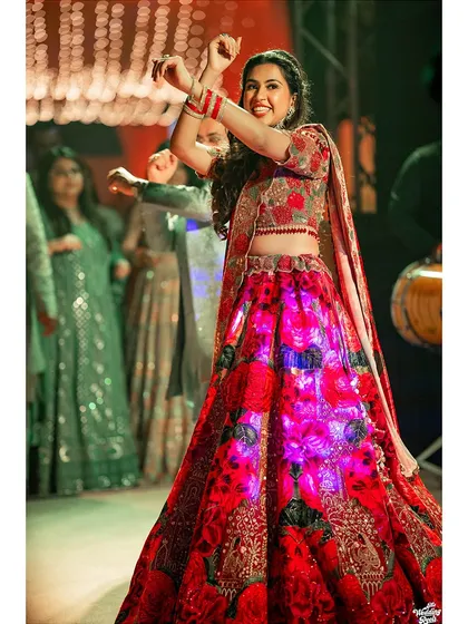 The bride owns the dance floor in her stunning illuminated lehenga during her Sangeet performance. A perfect shot of energy and celebration.