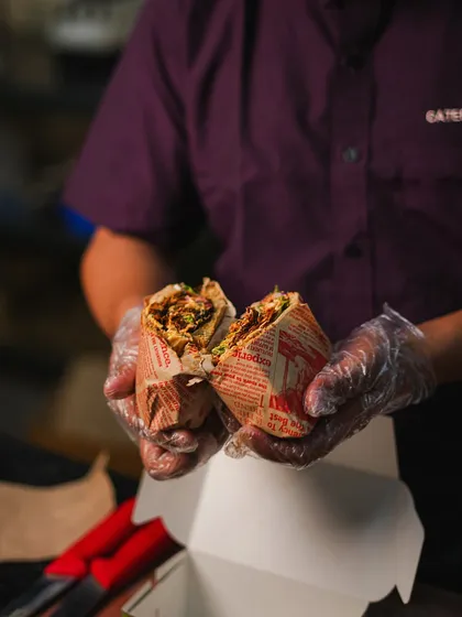 A close-up of a freshly made sandwich, held by our chef. This shot captures the delicious details and the care that goes into crafting each order.