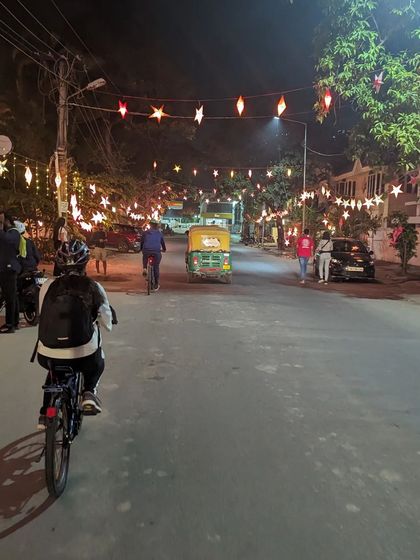 A rider cycles down a street beautifully decorated with Christmas stars. These festive rides add an extra layer of magic to our usual midnight explorations.
