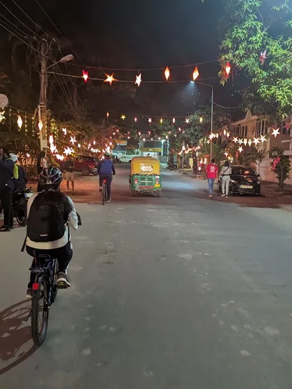 A rider cycles down a street beautifully decorated with Christmas stars. These festive rides add an extra layer of magic to our usual midnight explorations.