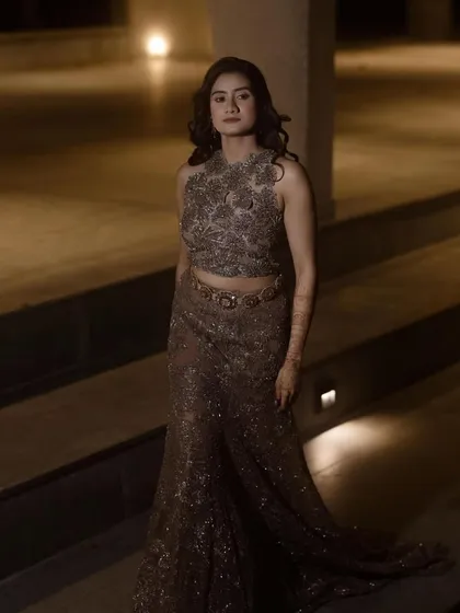 This bride owns the night in her gorgeous, shimmering Sangeet gown. The dramatic lighting highlights her elegant silhouette and the soft glam makeup we created for her.