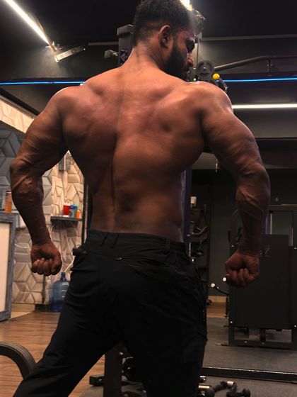 A powerful back double bicep pose, displaying the thickness and detail of the back muscles.