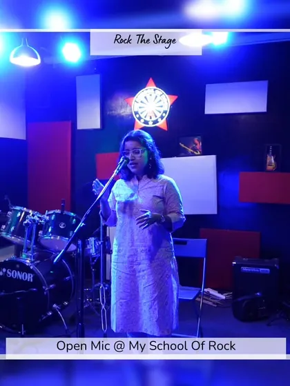 A poet performing her piece. The simple stage setup ensures the focus remains entirely on the artist and their craft.