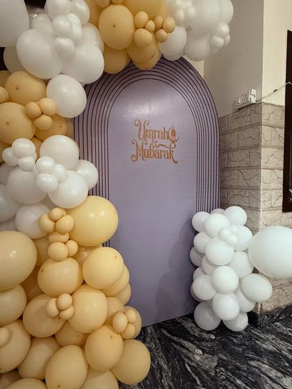 This image focuses on the custom 'Umrah Mubarak' backdrop, framed by the beautiful balloon garland. I can create custom backdrops for any religious or cultural event.