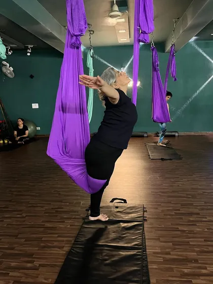 Age is no barrier in our studio. This member gracefully opens her chest in a supported backbend, showing how aerial yoga can be adapted for anyone looking to improve their mobility and strength.