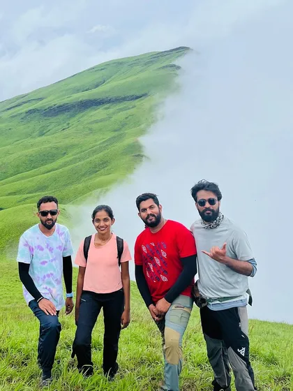 Four friends posing together against the iconic ridge of Netravathi peak.
