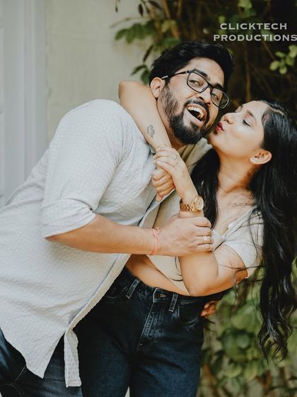 A joyful and energetic shot of the bride giving the groom a piggyback kiss, capturing their fun and loving relationship.